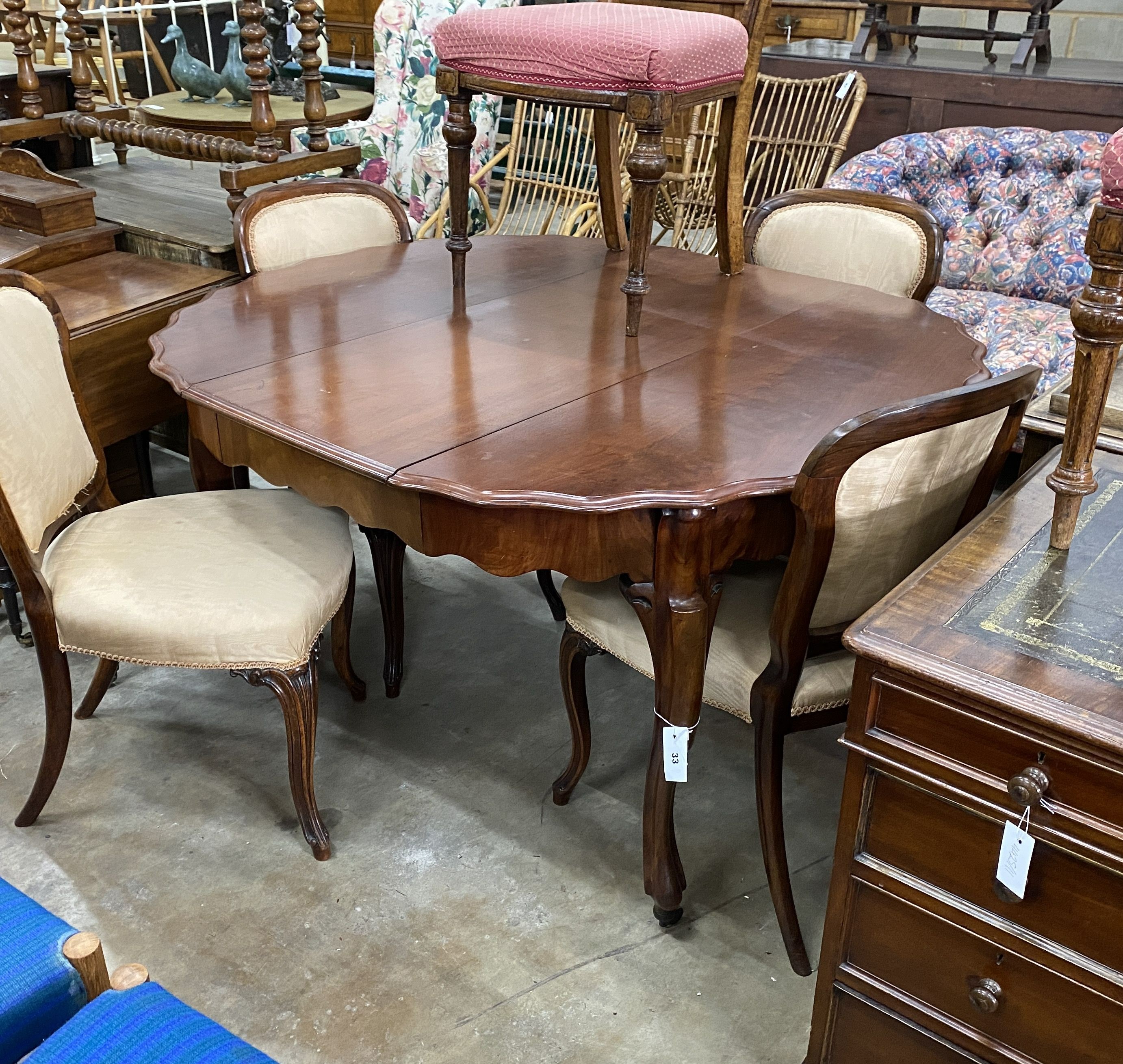 A 19th century French mahogany extending dining table on cabriole legs, width 134cm extended, one spare leaf, width 120cm, height 75cm